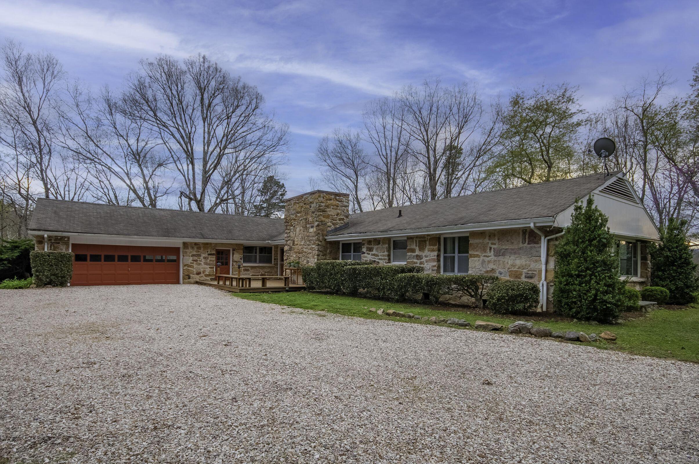 a view of an house with backyard and bushes