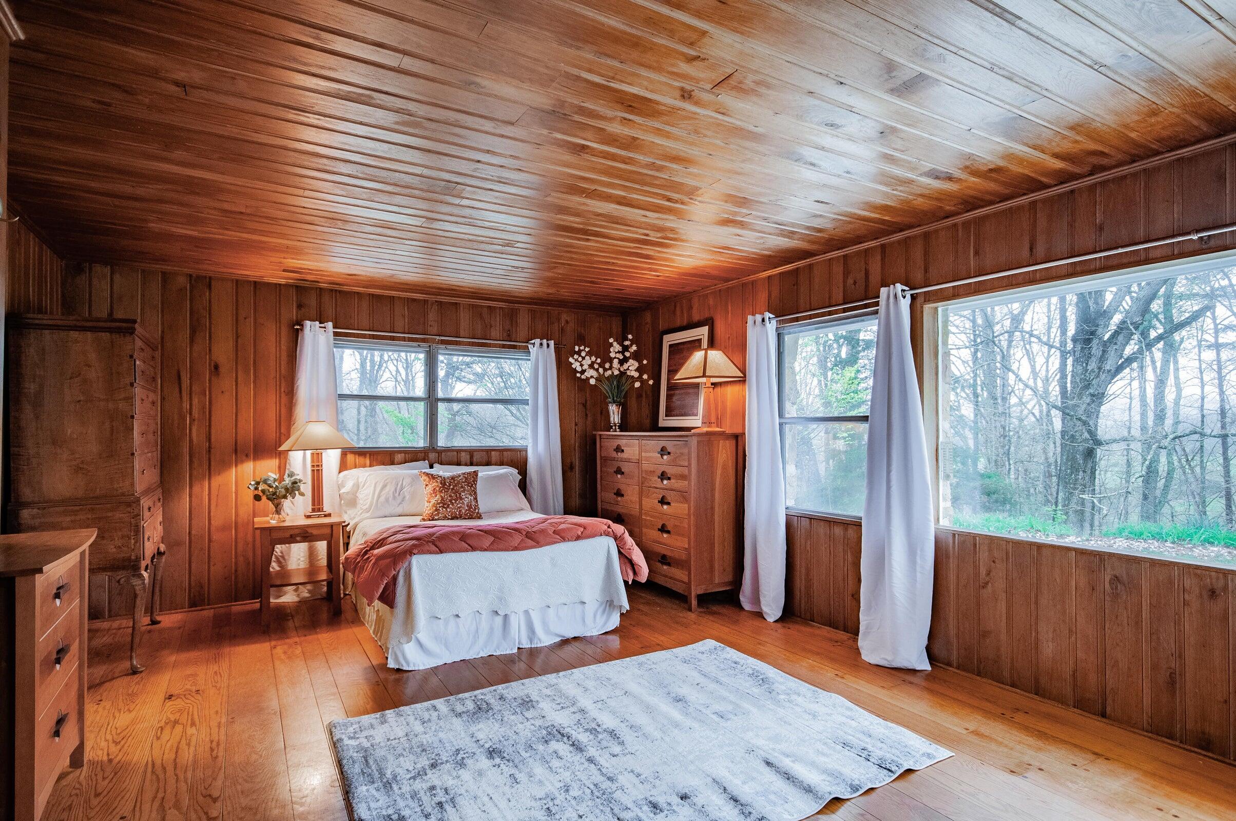 386 Fredericksburg Road Lexington, VA 24450 - Photo 23 of 72 a bedroom with a large bed and wooden floor