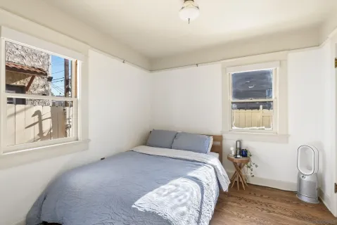 a bedroom with a bed and a window with chair