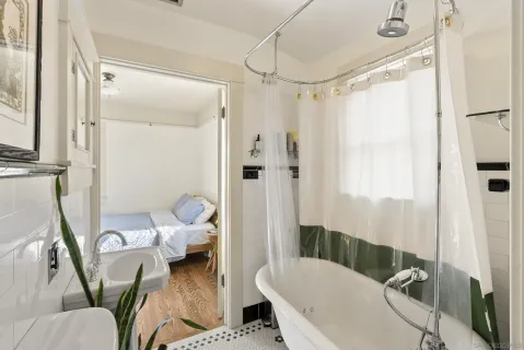 a bathroom with a tub toilet and shower