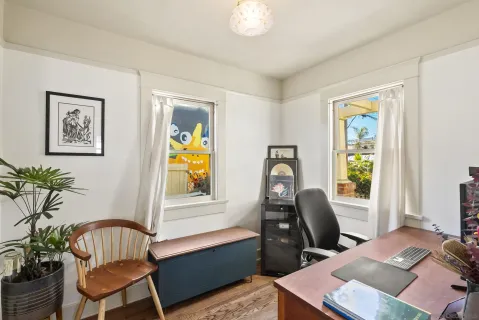 a view of a workspace with furniture and a window