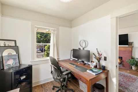 a view of a workspace with furniture and a window