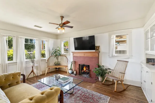 a living room with furniture a fireplace and a flat screen tv