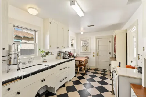 a large white kitchen with a sink and a window