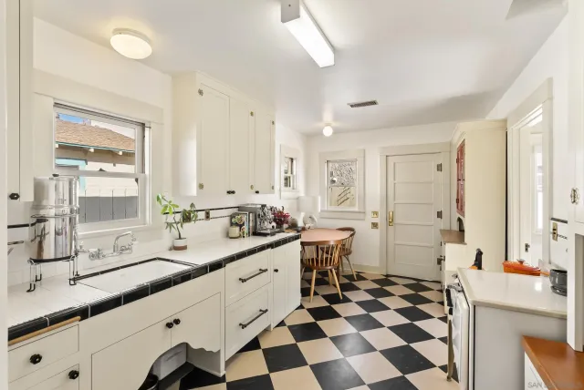 a large white kitchen with a sink and a window