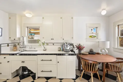a kitchen with a sink a stove a dining table and chairs