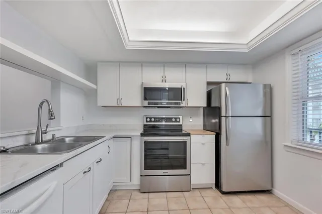 a kitchen with a refrigerator sink and cabinets