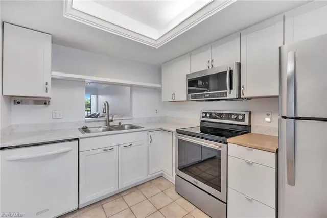 a kitchen with cabinets stainless steel appliances and a counter space