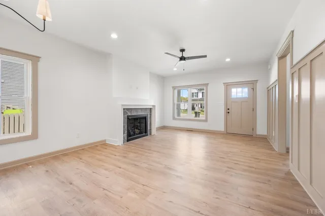 an empty room with windows and fireplace