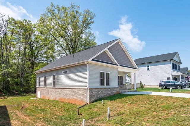 a view of a house with swimming pool next to a yard