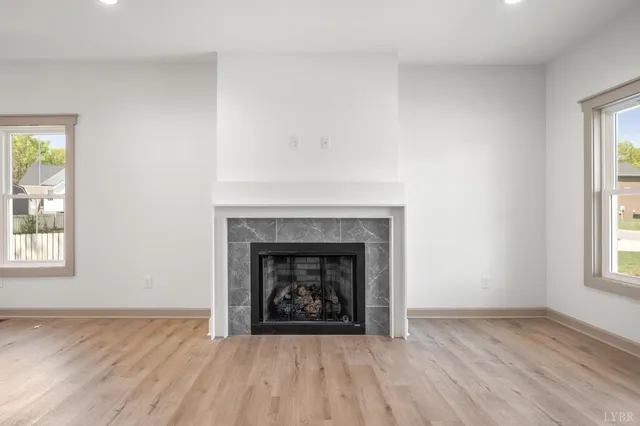 an empty room with windows and fireplace