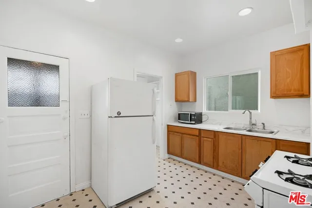 a kitchen with a sink a refrigerator and cabinets
