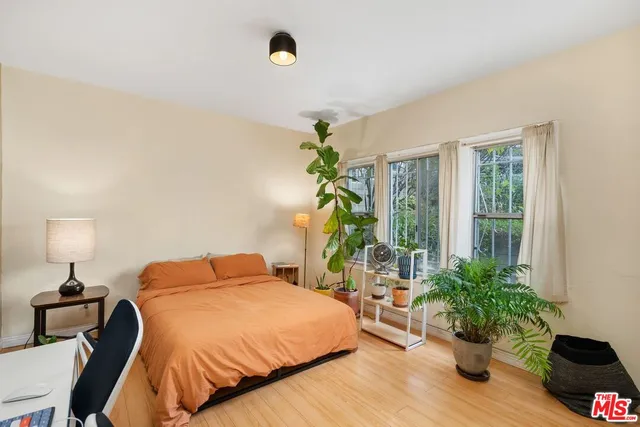 a bedroom with a bed potted plant with the outer view