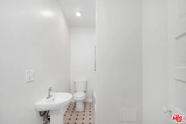a bathroom with a sink a toilet and a mirror