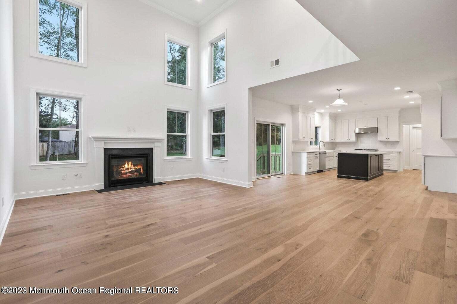 2 Crine Road Morganville, NJ 07751 - Photo 4 of 15 a view of a livingroom with a fireplace a ceiling fan and windows