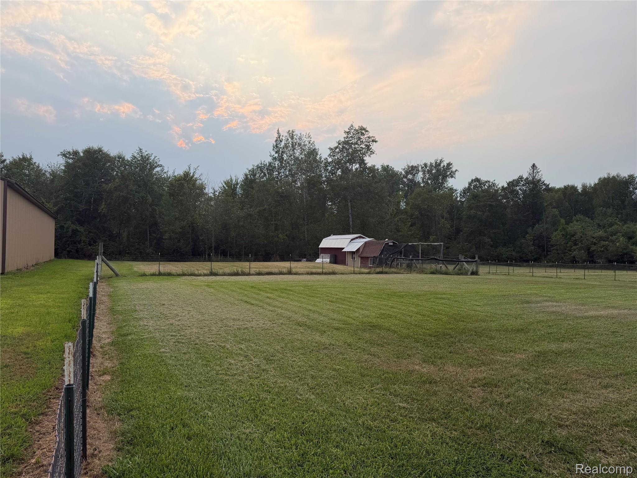 2402 Mertz Road Caro, MI 48723 - Photo 22 of 26 Expansive open pasture with a perimeter fence, mature tree line, and a secondary structure