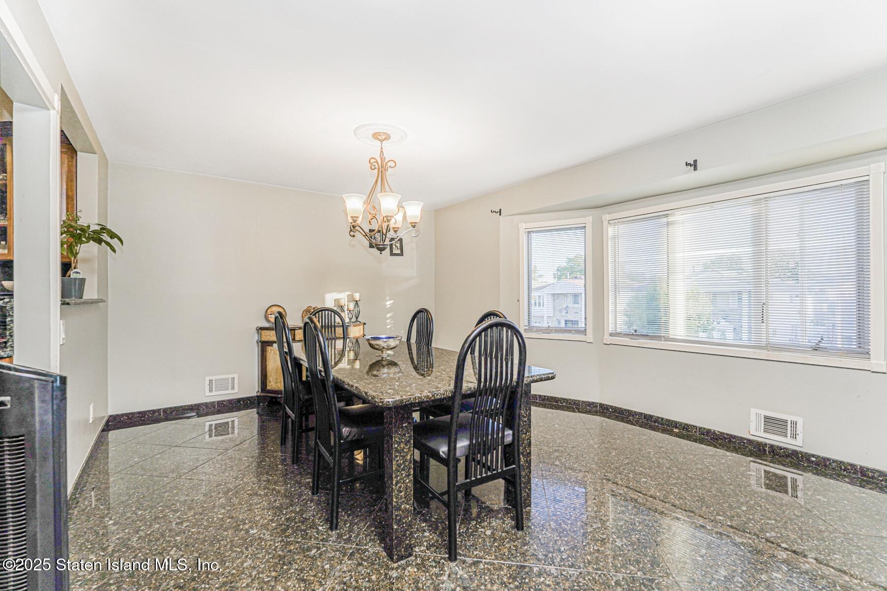 31 Plank Road Staten Island, NY 10314 - Photo 12 of 30 a view of a dining room with furniture a chandelier and wooden floor