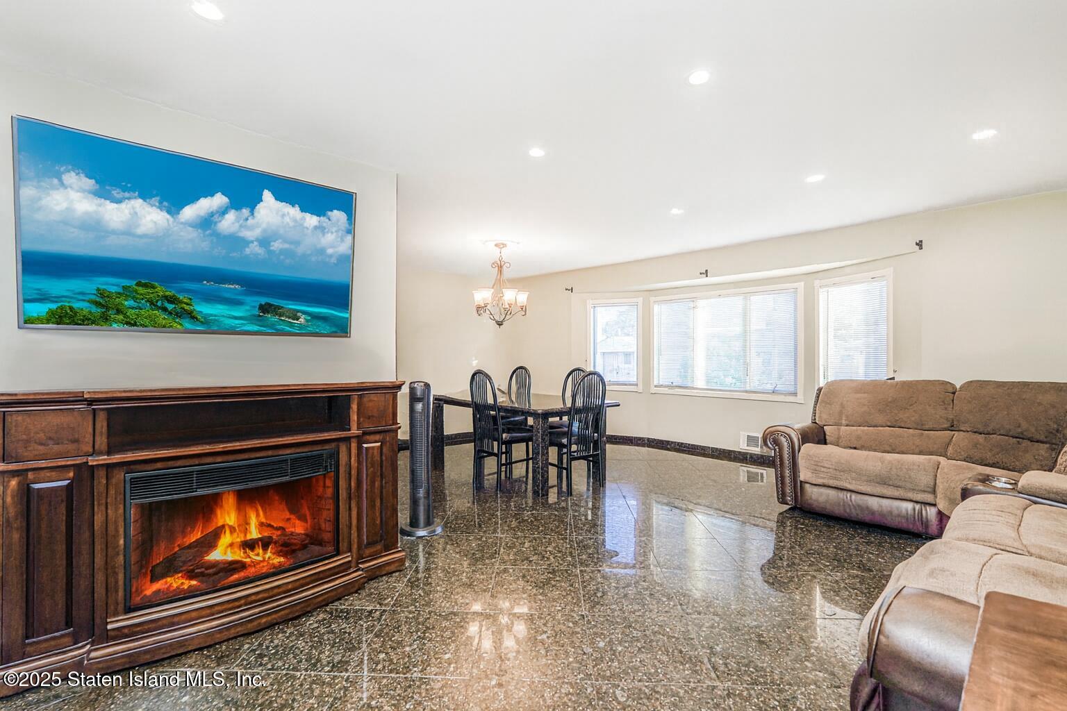 31 Plank Road Staten Island, NY 10314 - Photo 13 of 30 a living room with furniture a flat screen tv and a fireplace
