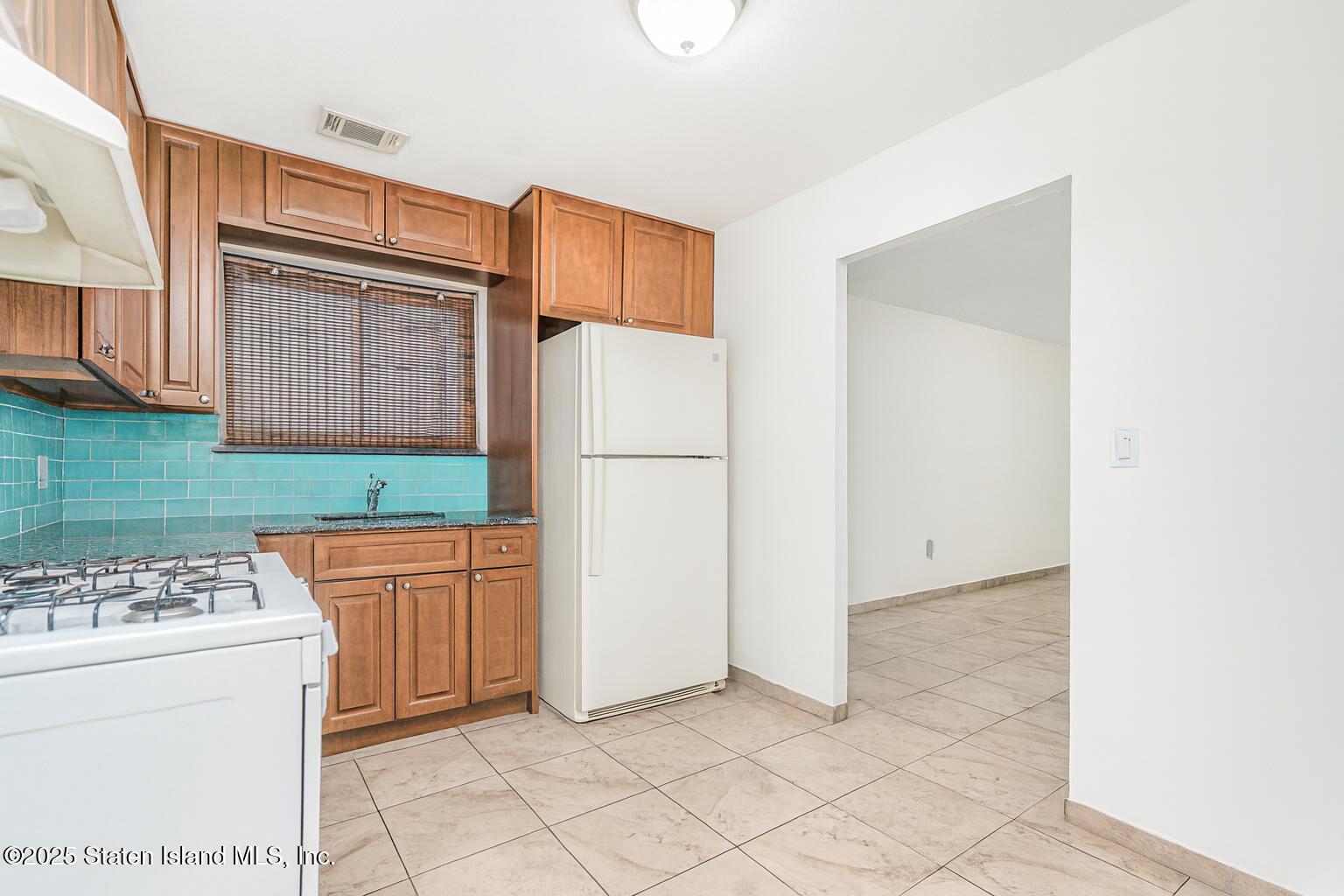 31 Plank Road Staten Island, NY 10314 - Photo 24 of 30 a kitchen with stainless steel appliances a refrigerator sink and cabinets