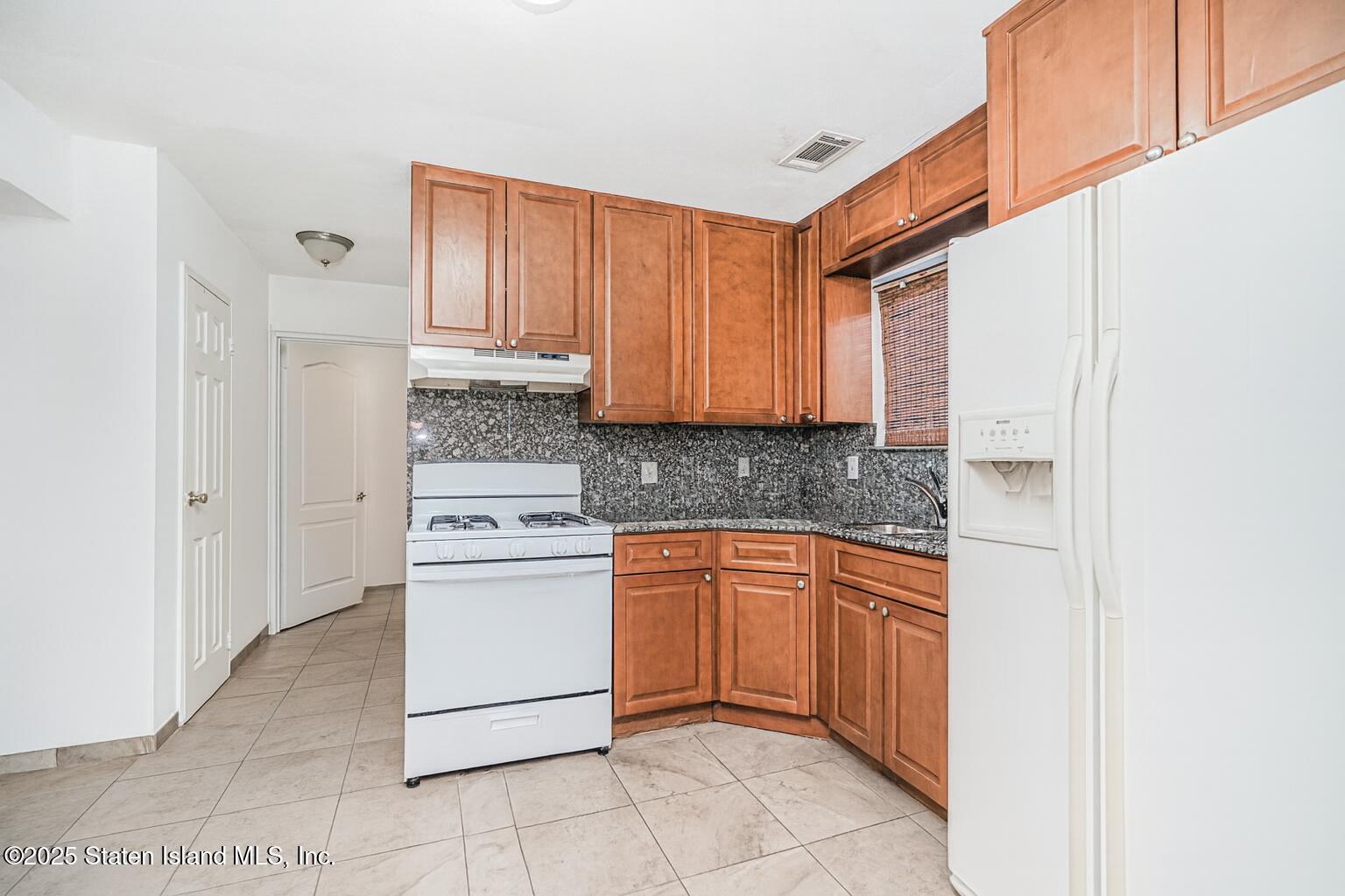31 Plank Road Staten Island, NY 10314 - Photo 25 of 30 a kitchen with stainless steel appliances granite countertop a refrigerator and a stove top oven