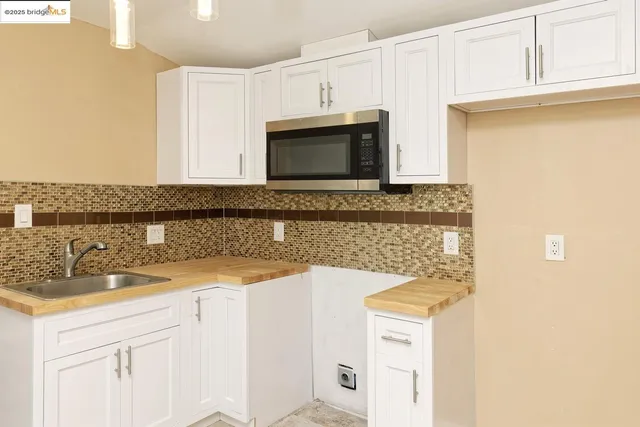 a kitchen with stainless steel appliances granite countertop a sink and a microwave