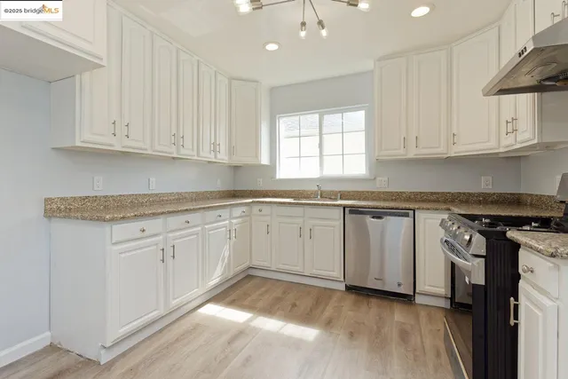 a kitchen with granite countertop white cabinets and white appliances
