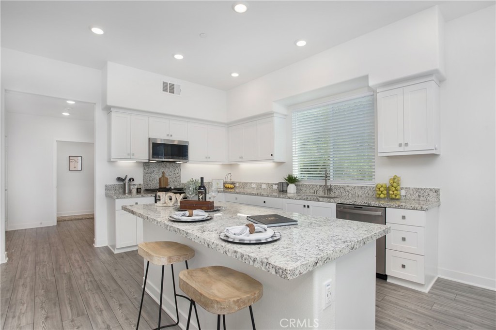 1891 Union Street, Unit 107 Anaheim, CA 92805 - Photo 1 of 1 a kitchen with sink stove microwave and cabinets with wooden floor