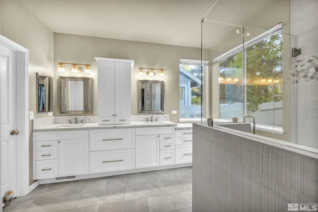 a bathroom with sinks mirror and a shower