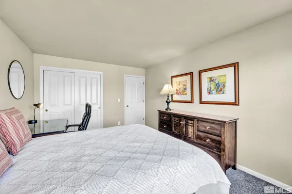a bedroom with a bed and dresser with mirror