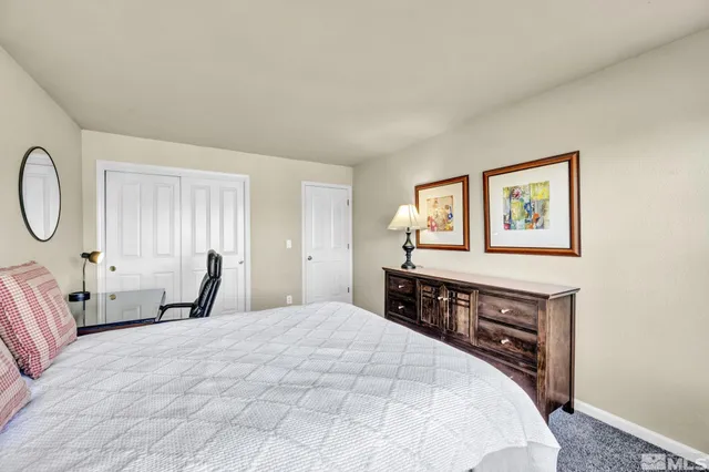 a bedroom with a bed and dresser with mirror