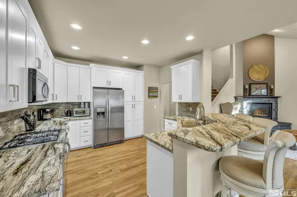 a kitchen with stainless steel appliances kitchen island granite countertop a refrigerator and a stove top oven