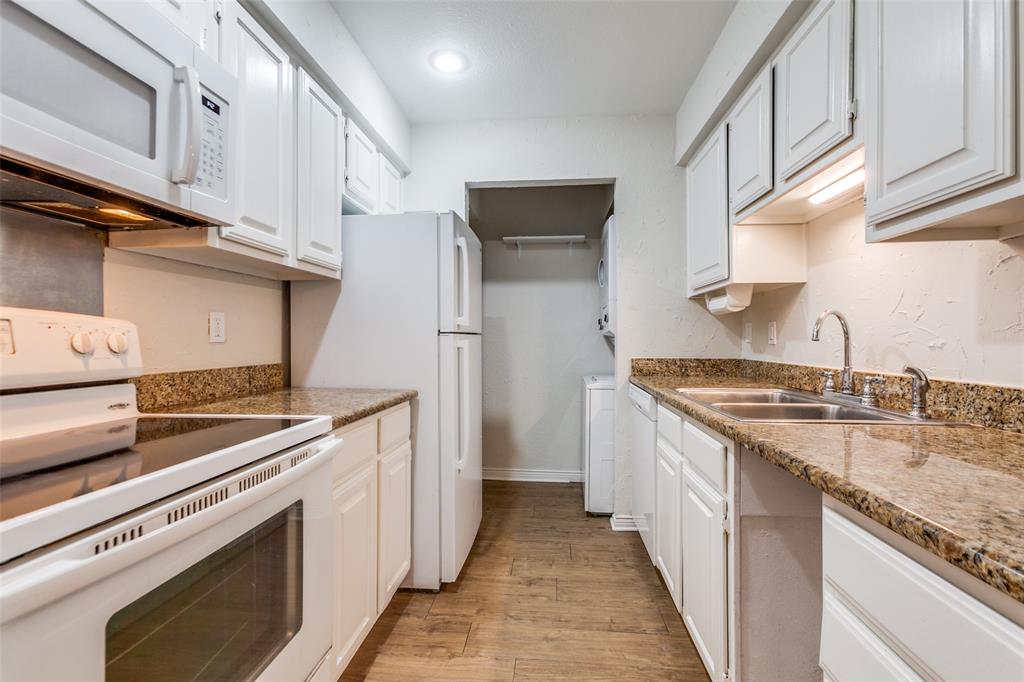 6122 Ridgecrest Road, Unit 2007 Dallas, TX 75231 - Photo 8 of 13 Kitchen with white appliances, light wood-type flooring, white cabinetry, and dark stone countertops