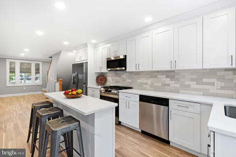 a kitchen with a sink cabinets and wooden floor
