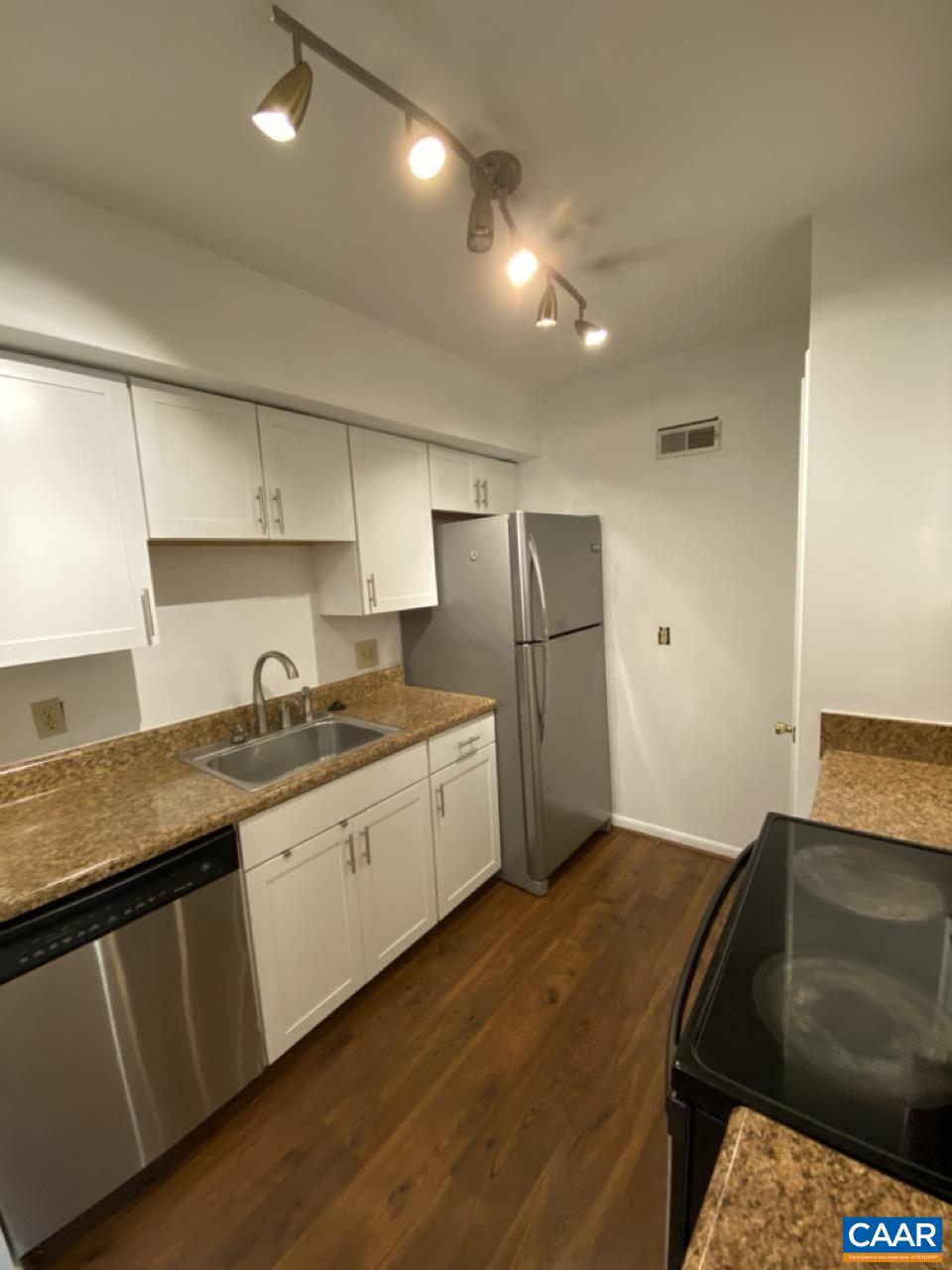 102 Turtle Creek Road, Unit 1 Charlottesville, VA 22901 - Photo 7 of 26 a kitchen with a sink a refrigerator and cabinets
