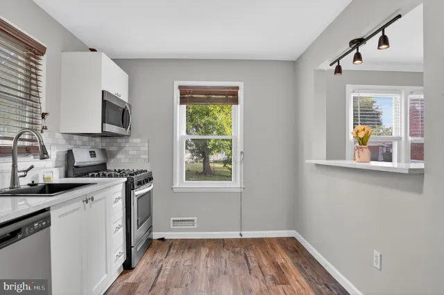 a kitchen with granite countertop a stove a sink and a microwave
