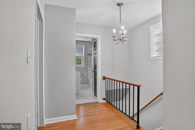 a view of a hallway with windows and chandelier