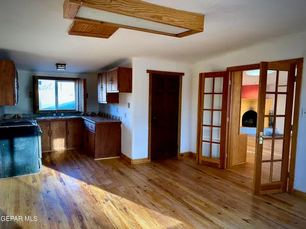 a kitchen view with wooden floor counter top space and stainless steel appliances