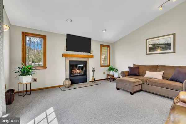 a kitchen with stainless steel appliances granite countertop a stove top oven a sink dishwasher a dining table and chairs with wooden floor