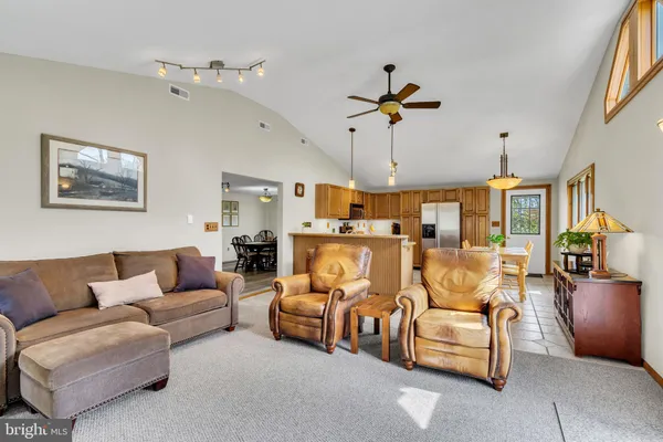 a kitchen with stainless steel appliances granite countertop a stove top oven a sink dishwasher a dining table and chairs with wooden floor