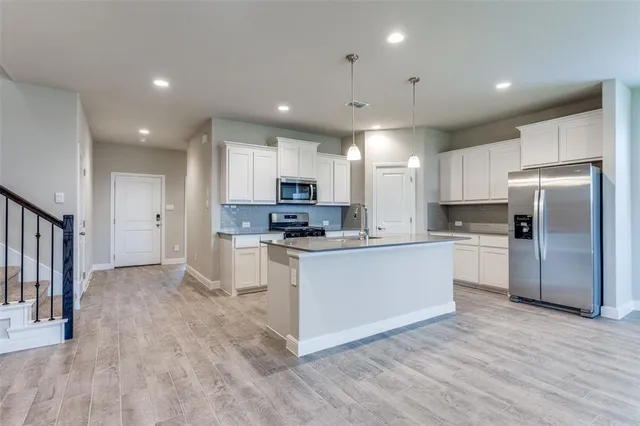 a kitchen with white cabinets and stainless steel appliances