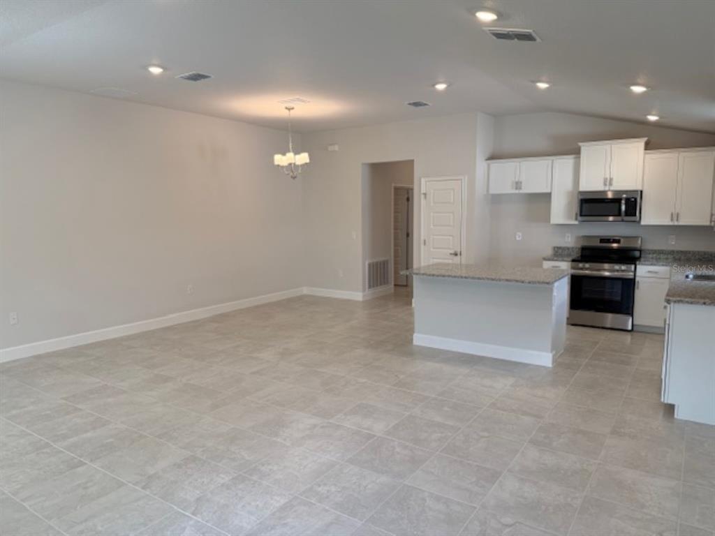 2150 Northwest 23rd Loop Ocala, FL 34475 - Photo 15 of 19 a view of kitchen with kitchen island white cabinetry and stainless steel appliances
