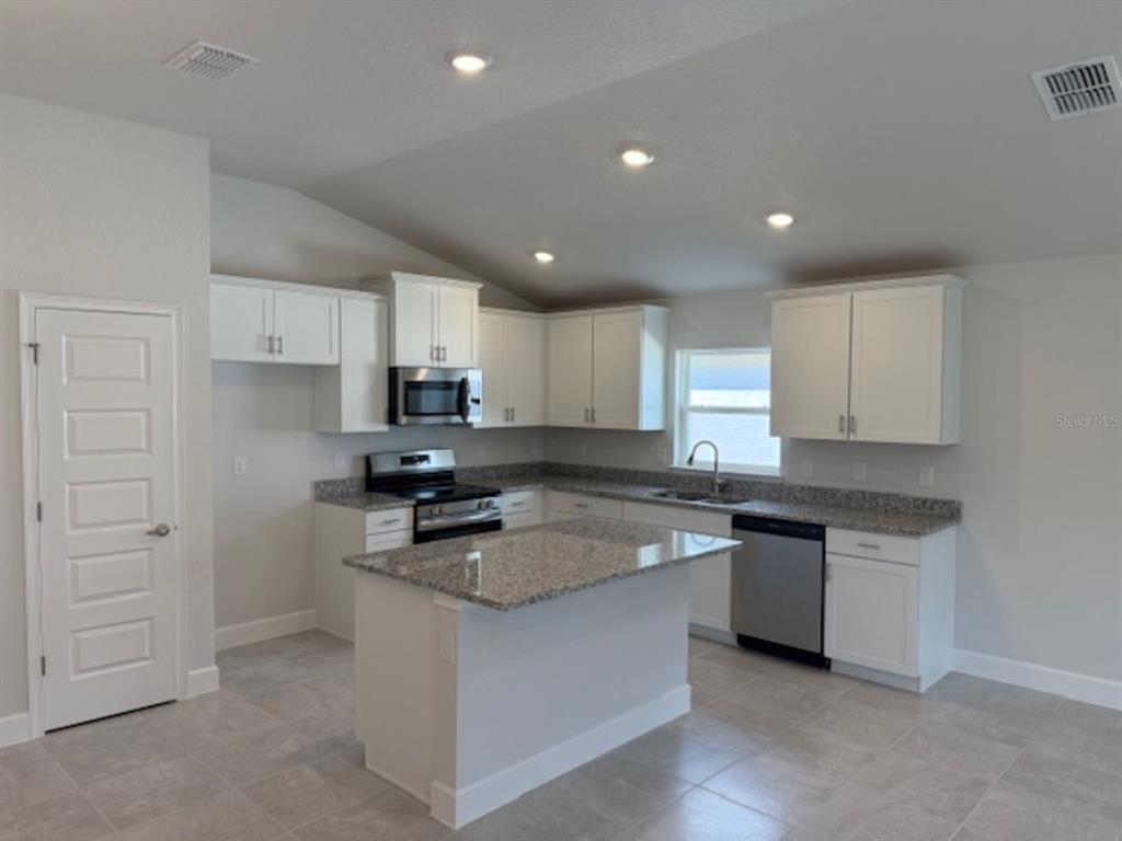 2150 Northwest 23rd Loop Ocala, FL 34475 - Photo 2 of 19 a kitchen with cabinets appliances a sink and a counter top space