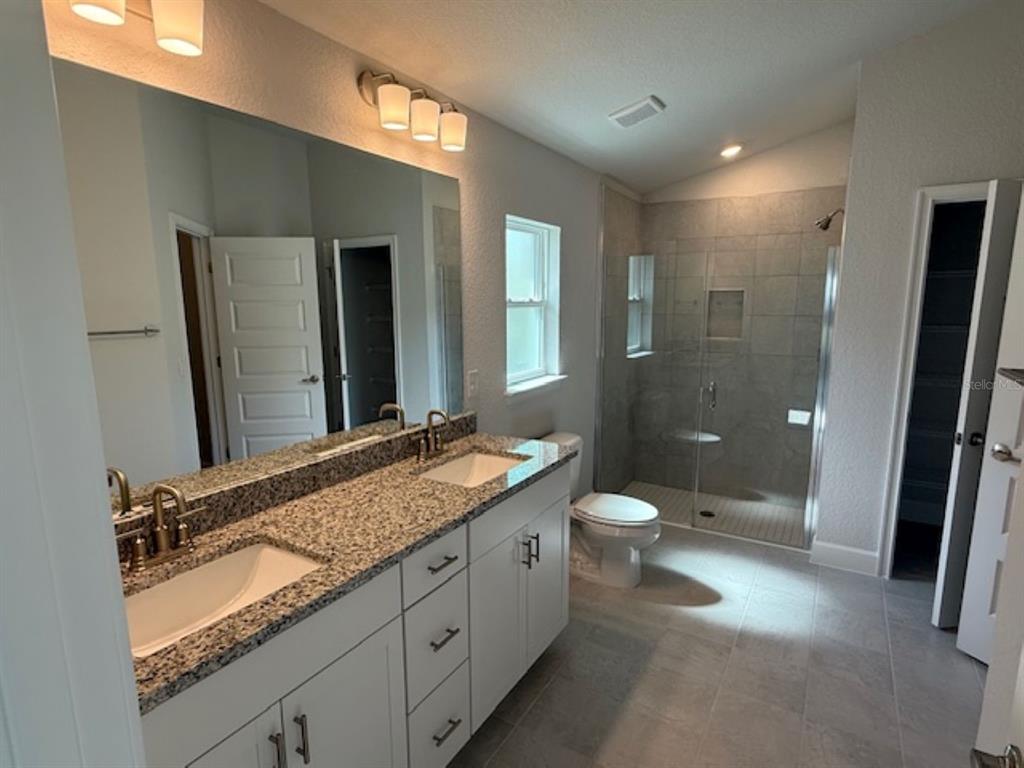 2150 Northwest 23rd Loop Ocala, FL 34475 - Photo 3 of 19 a bathroom with a granite countertop sink toilet and shower