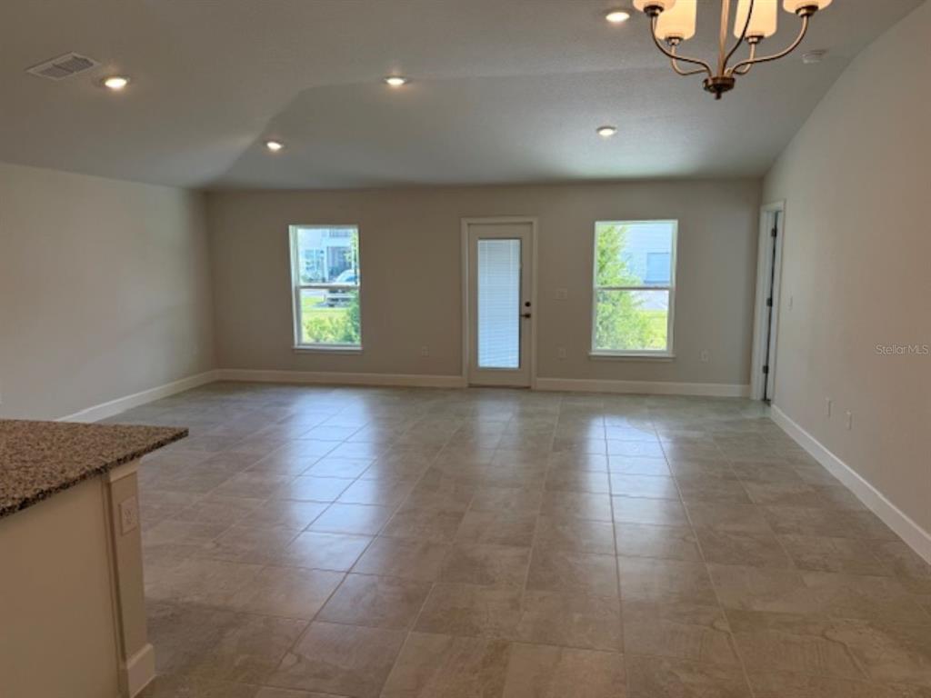 2150 Northwest 23rd Loop Ocala, FL 34475 - Photo 4 of 19 an empty room with wooden floor and windows