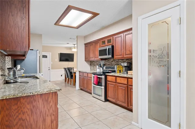 a kitchen with stainless steel appliances granite countertop a refrigerator stove and sink