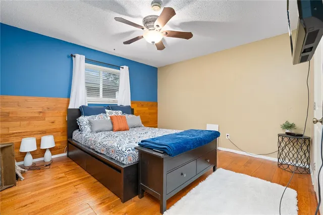 a bedroom with a bed and a potted plant on the dresser