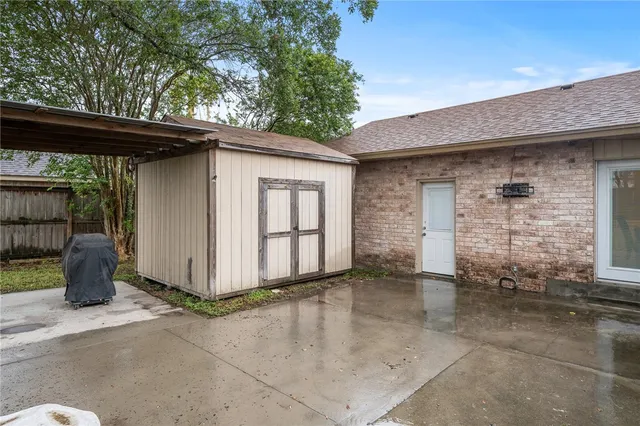 a backyard of a house with barbeque oven table and chairs