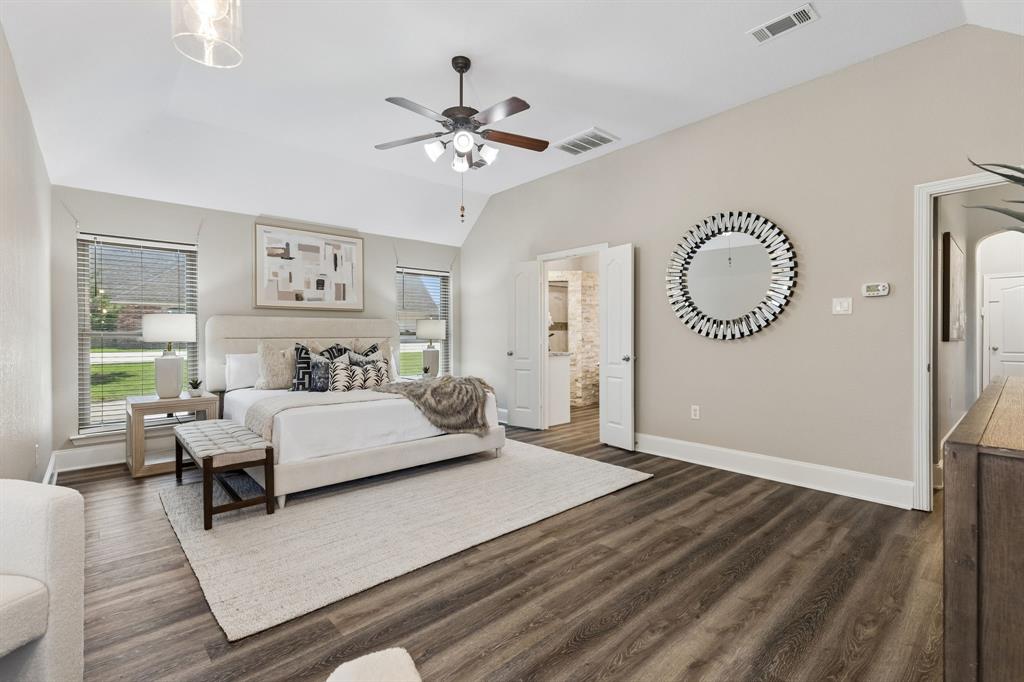 317 Singing Quail Trail Haslet, TX 76052 - Photo 14 of 32 Vaulted ceilings enhance this room, featuring wood-finish flooring, two windows with blinds, a ceiling fan, and access to an additional space