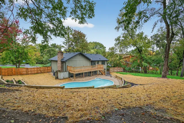 a large kitchen with stainless steel appliances a large center island attached withe living room