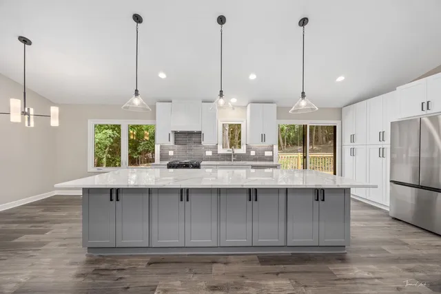 a kitchen with kitchen island a sink a stove and wooden floor